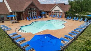 A swimming pool surrounded by lounge chairs and umbrellas near the clubhouse at The Waterways of Lake Saint Louis.