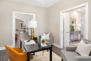A bonus room with hardwood-style flooring and access to the main living area and another room in a 4-bedroom rental home.