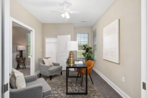 A 3-bedroom cottage adjoined bonus room being used as an office space with a closet and two windows.