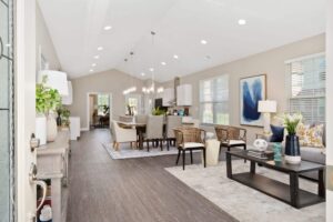 Entryway into a 3-bedroom cottage, showing an open-concept living room, dining room, and kitchen with large windows.